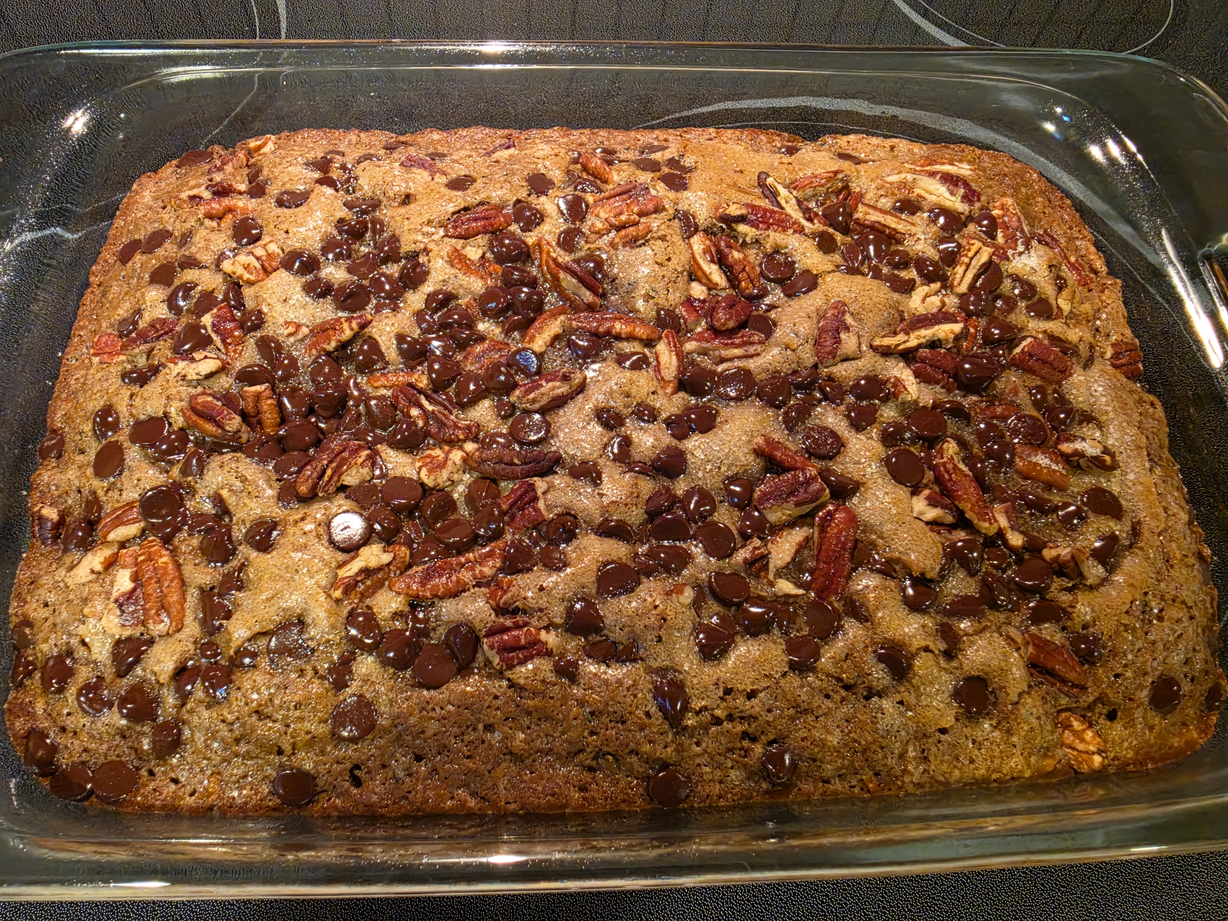 Chocolate zucchini cake topped with pecans and chocolate chips